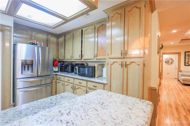 kitchen with visible vents, light wood-style floors, stainless steel refrigerator with ice dispenser, and black microwave