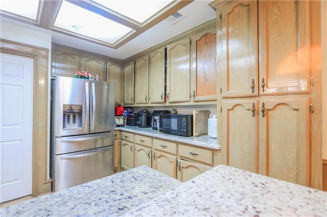 kitchen featuring visible vents, black microwave, and stainless steel fridge with ice dispenser