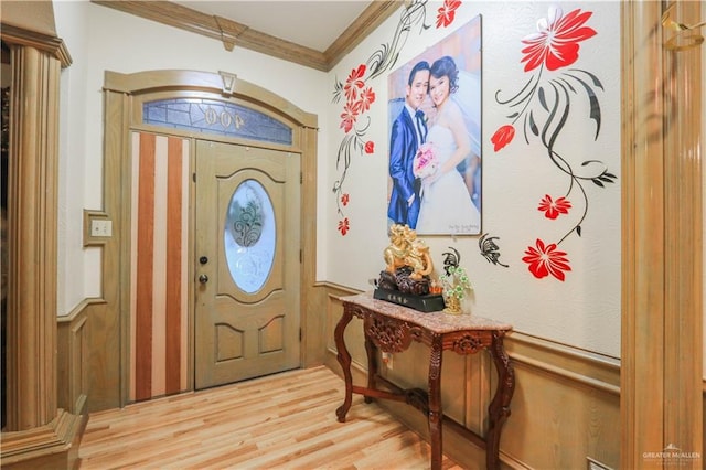 entrance foyer featuring crown molding and light wood-style flooring