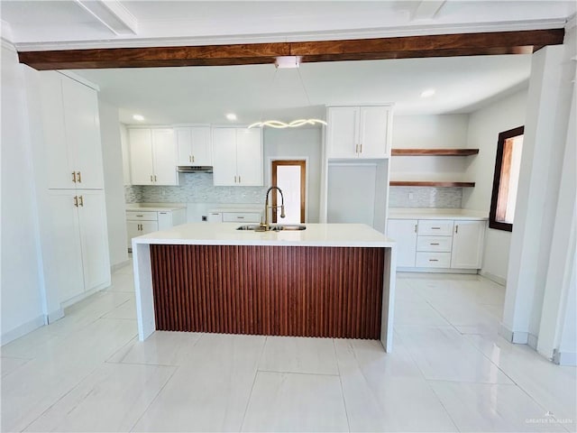 612 E Tom Landry St, Mission, TX 78572 - kitchen featuring backsplash, a kitchen island with sink, white cabinetry, beam ceiling, and under cabinet range hood