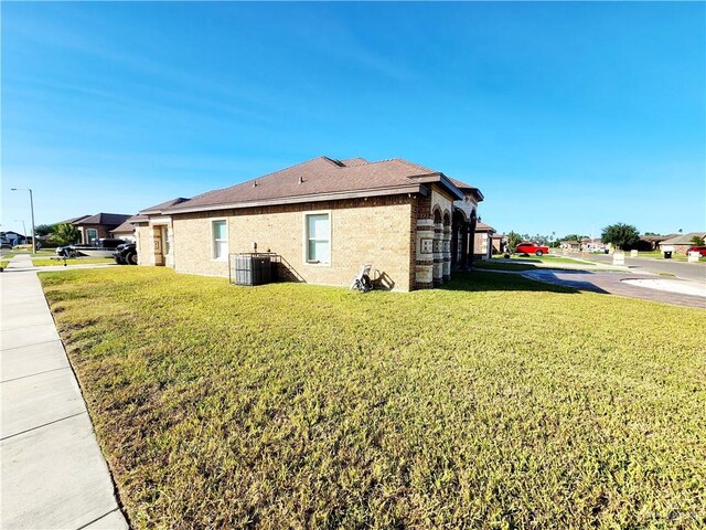 view of property exterior featuring central air condition unit and a lawn