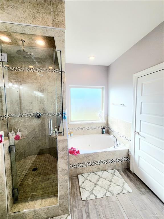 bathroom featuring shower with separate bathtub and hardwood / wood-style floors