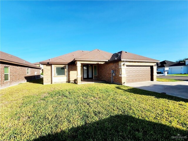 ranch-style house featuring a front yard and a garage