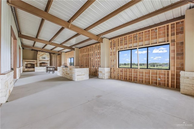 misc room with concrete flooring and a stone fireplace