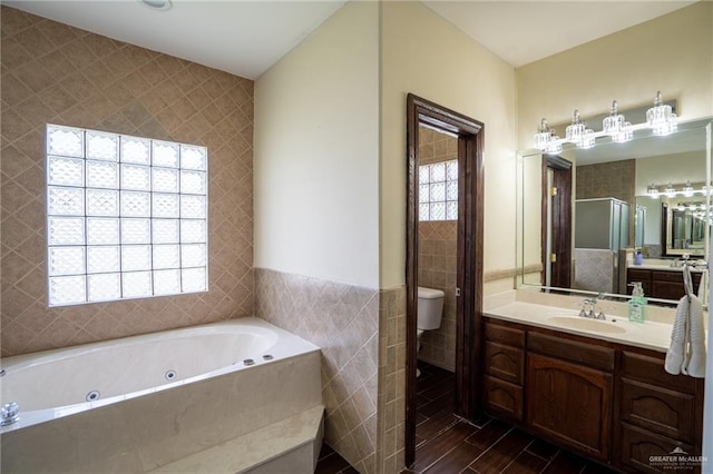 full bathroom with vanity, toilet, plenty of natural light, and tile walls