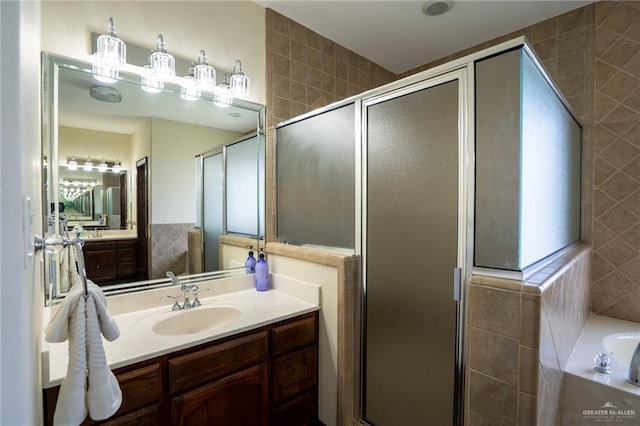 bathroom featuring vanity and shower with separate bathtub