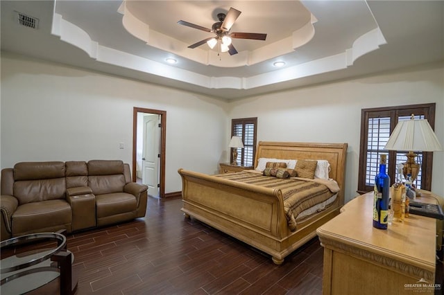 bedroom featuring a raised ceiling and ceiling fan