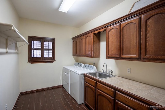 washroom with washer and clothes dryer, cabinets, and sink