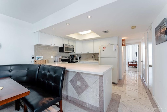 110 Padre Blvd Unit 603, South Padre Island, TX 78597 - kitchen with tasteful backsplash, appliances with stainless steel finishes, a peninsula, light countertops, and light tile patterned floors