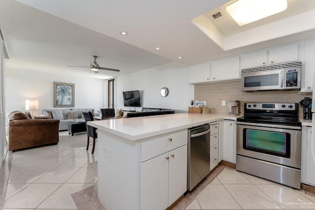 110 Padre Blvd Unit 603, South Padre Island, TX 78597 - kitchen featuring light tile patterned floors, visible vents, a peninsula, stainless steel appliances, and tasteful backsplash