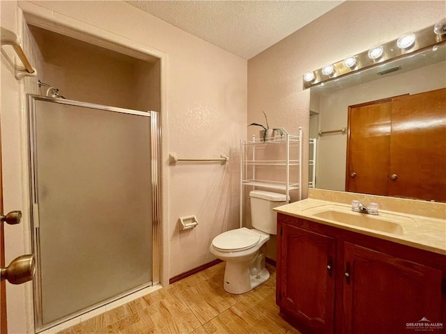 bathroom featuring vanity, an enclosed shower, a textured ceiling, and toilet