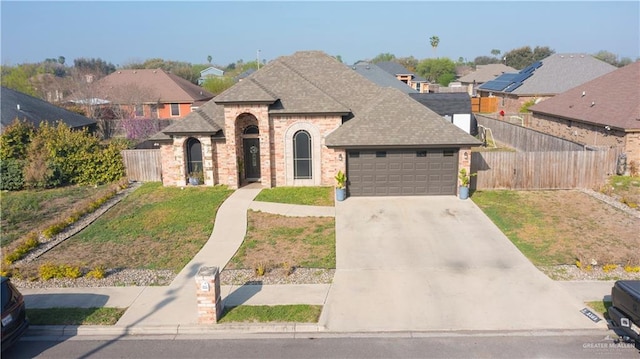 french country home with brick siding, fence, a garage, driveway, and a front lawn