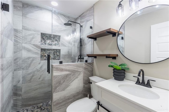 bathroom featuring toilet, a shower stall, and vanity