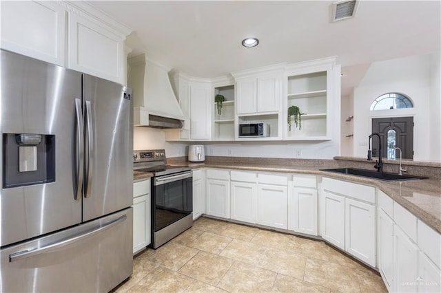 kitchen with visible vents, custom range hood, appliances with stainless steel finishes, open shelves, and a sink