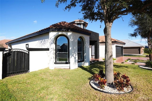 mediterranean / spanish house featuring a garage and a front yard