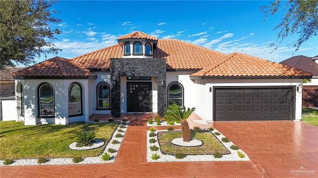 mediterranean / spanish home featuring a garage and a front lawn