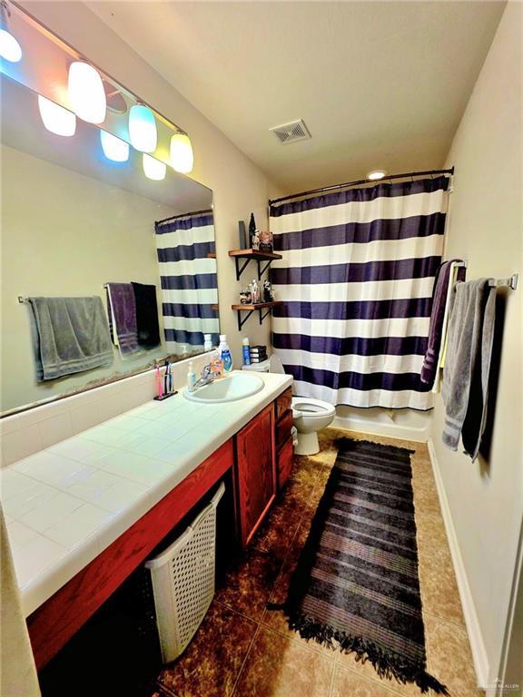 1920 Katherine Ave, Edinburg, TX 78539 - full bathroom featuring vanity, toilet, and tile patterned floors