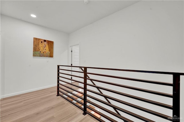 corridor featuring recessed lighting, baseboards, light wood-style flooring, and an upstairs landing