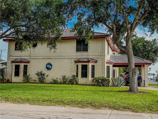 1712 N 1st St, Mcallen, TX 78501 - mediterranean / spanish home featuring a tiled roof, concrete driveway, a front yard, and a carport
