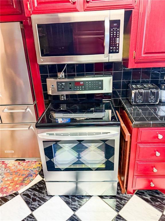1712 N 1st St, Mcallen, TX 78501 - kitchen featuring backsplash, dark countertops, and stainless steel appliances