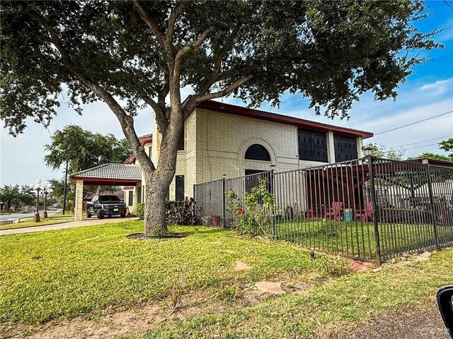1712 N 1st St, Mcallen, TX 78501 - view of side of property featuring fence, a lawn, brick siding, and a carport