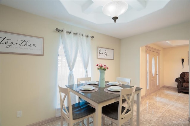 dining space featuring baseboards and arched walkways