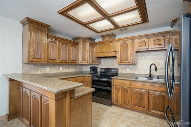 kitchen featuring a peninsula, range with electric stovetop, a sink, custom exhaust hood, and freestanding refrigerator