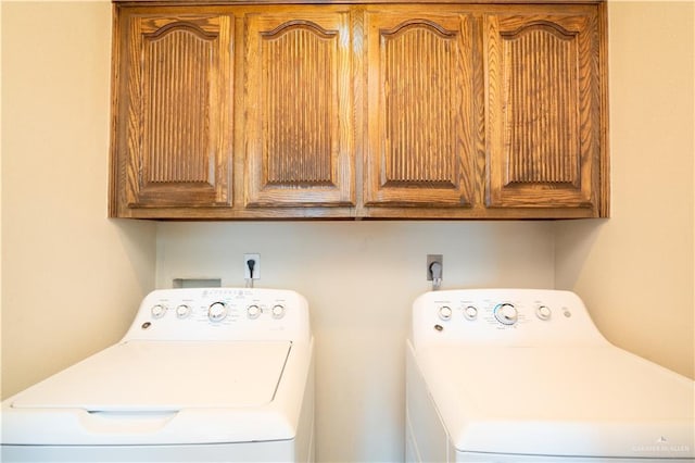 clothes washing area featuring cabinet space and independent washer and dryer