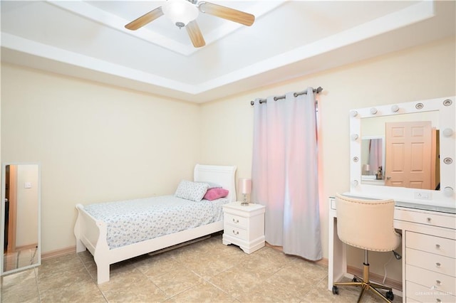 bedroom featuring a ceiling fan, a raised ceiling, and baseboards