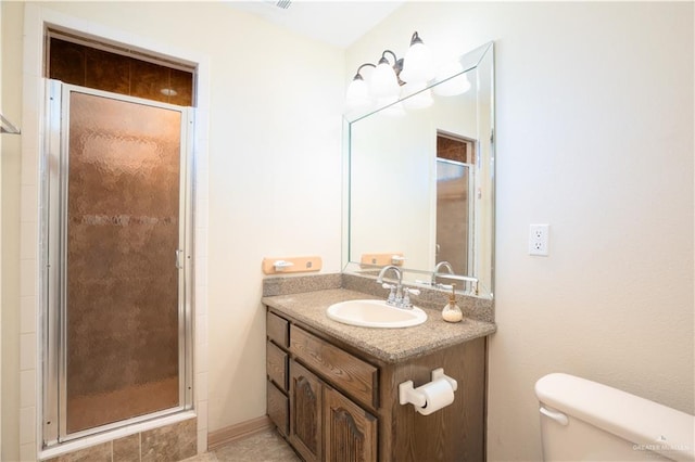 bathroom with toilet, a shower stall, and vanity