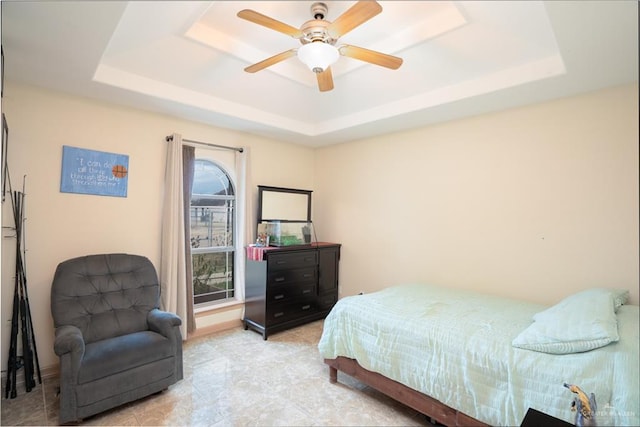 bedroom featuring ceiling fan, baseboards, and a raised ceiling