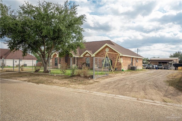 view of front of home featuring brick siding, central AC unit, and fence