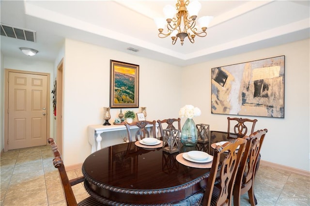 dining room featuring an inviting chandelier, visible vents, a tray ceiling, and baseboards