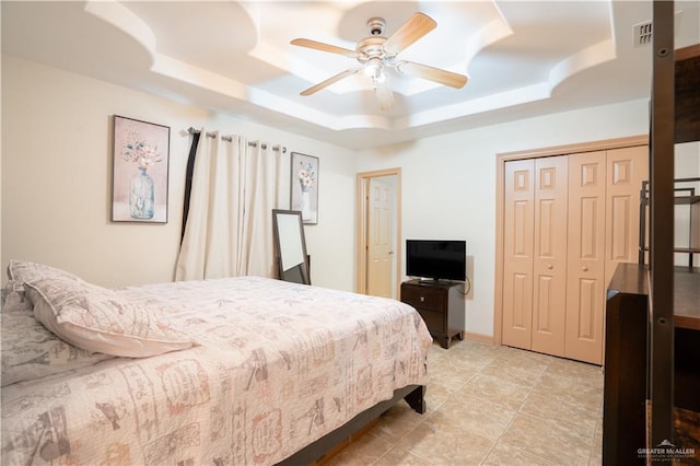 bedroom with visible vents, baseboards, a raised ceiling, and a ceiling fan