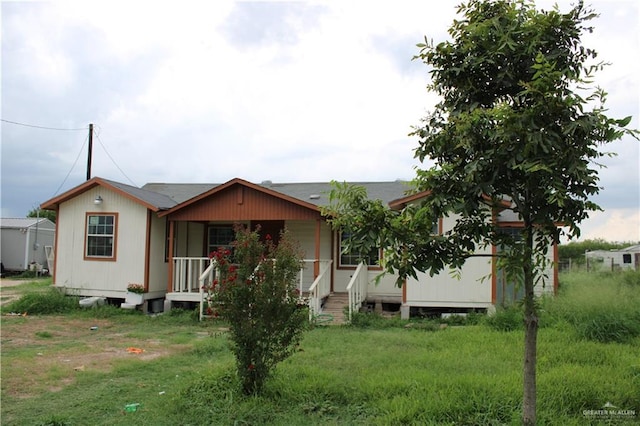 view of front of home featuring covered porch and a front lawn