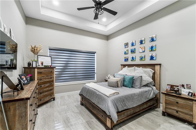 bedroom with a raised ceiling and ceiling fan