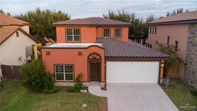 mediterranean / spanish house featuring a front lawn and a garage