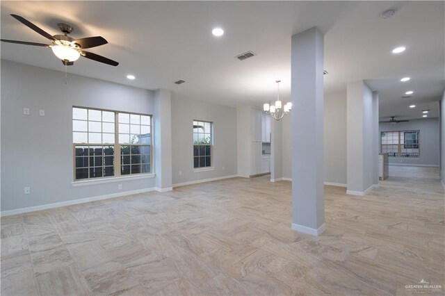 unfurnished living room featuring ceiling fan with notable chandelier