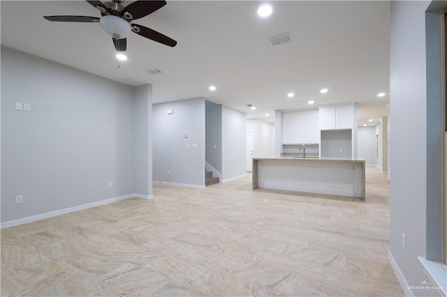 unfurnished living room with ceiling fan and sink