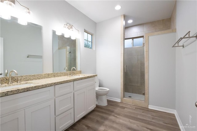 bathroom featuring toilet, hardwood / wood-style floors, vanity, and walk in shower