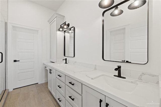 2413 N Gaytan Ave, Edinburg, TX 78542 - bathroom featuring double vanity, a shower stall, and wood finished floors