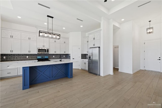 2413 N Gaytan Ave, Edinburg, TX 78542 - kitchen with stainless steel appliances, a sink, tasteful backsplash, white cabinets, and light countertops