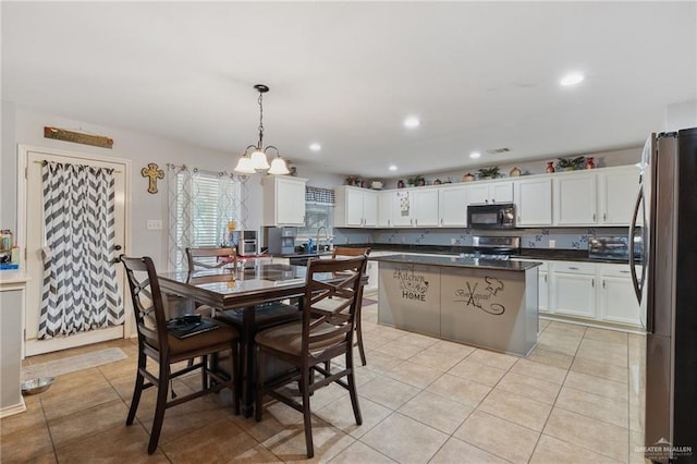 dining area featuring sink, light tile patterned flooring, and an inviting chandelier