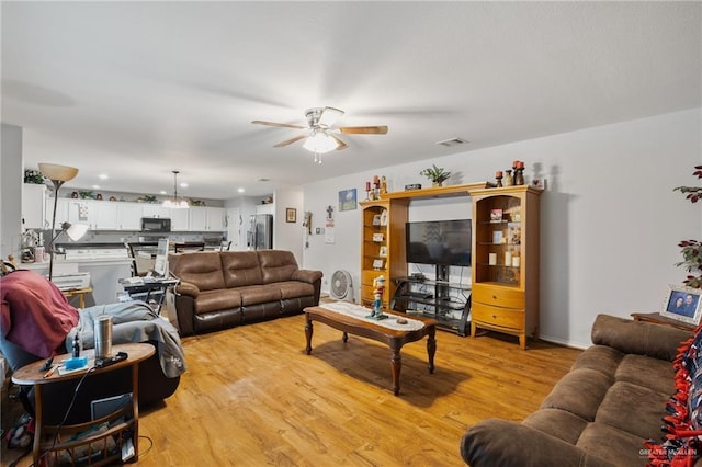 living room featuring ceiling fan and light hardwood / wood-style flooring