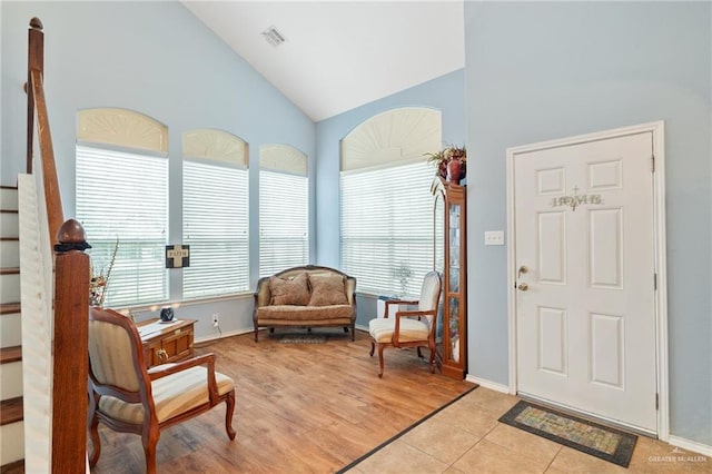 living area featuring light tile patterned floors and high vaulted ceiling