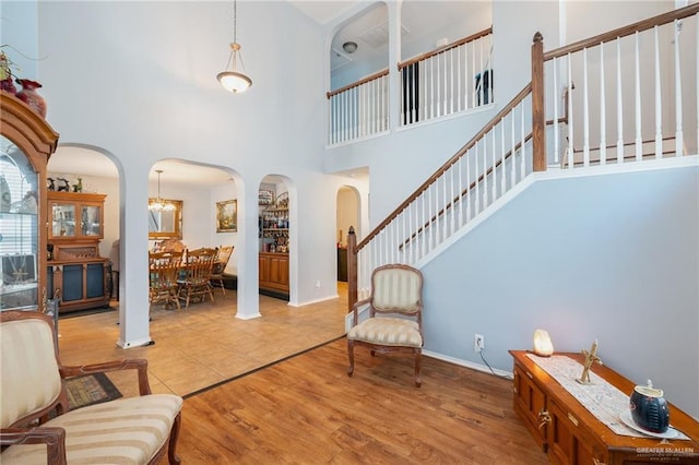 entrance foyer featuring light wood-type flooring and a towering ceiling