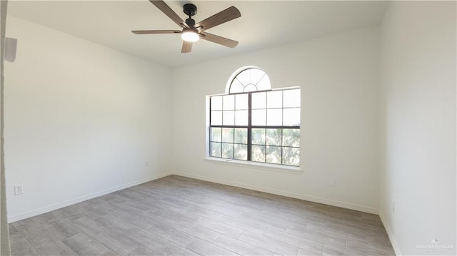 unfurnished room featuring ceiling fan, wood finished floors, and baseboards