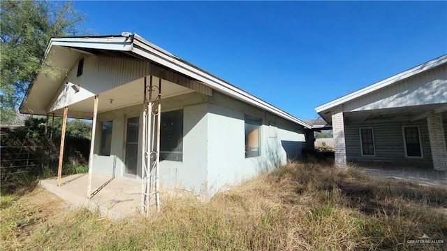 view of side of home featuring stucco siding and a sunroom