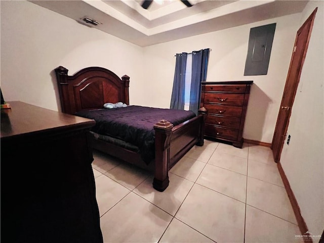 bedroom featuring a raised ceiling, light tile patterned floors, and electric panel