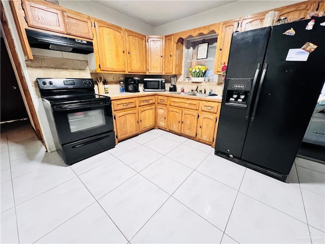 kitchen featuring sink, light tile patterned floors, and black appliances